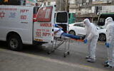 Magen David Adom medical team members transfer an Israeli man, suspected of being Covid-19 positive, in the ultra-Orthodox city of Bnei Brak, March 31, 2020. (Gili Yaari/Flash90)