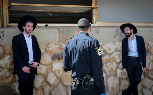 Israeli police officers remove ultra-Orthodox men from the Ponevezh Yeshiva in Bnei Brak, as part of an effort to enforce a lockdown in order to prevent the spread of the coronavirus on April 2, 2020. (Flash90) Israeli police officers remove ultra-Orthodox men from the Ponevezh Yeshiva in Bnei Brak, as part of an effort to enforce a lockdown in order to prevent the spread of the coronavirus on April 2, 2020. (Flash90)