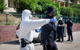 Israeli police officers remove ultra-Orthodox men from the Ponevezh Yeshiva in Bnei Brak, as part of an effort to enforce a lockdown in order to prevent the spread of the coronavirus on April 2, 2020. (Flash90)