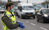 An IDF soldier at a temporary checkpoint in Jerusalem to check that Israelis are not violating restrictions meant to contain the coronavirus, April 2, 2020. (Nati Shohat//Flash90)