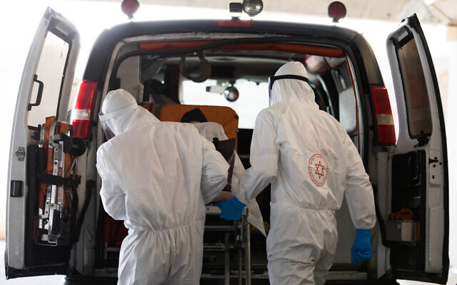 Magen David Adom workers wearing protective clothing, as a preventive measure against the coronavirus evacuate a patient with suspicion to coronavirus outside the new coronavirus unit at Shaare Zedek hospital in Jerusalem on April 3, 2020. (Nati Shohat/Flash90) Magen David Adom workers wearing protective clothing, as a preventive measure against the coronavirus evacuate a patient with suspicion to coronavirus outside the new coronavirus unit at Shaare Zedek hospital in Jerusalem on April 3, 2020. (Nati Shohat/Flash90)