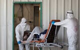 Magen David Adom workers wearing protective clothing as a preventive measure against the coronavirus evacuate a patient with suspected coronavirus outside a coronavirus unit at Shaare Zedek hospital in Jerusalem on April 3, 2020. ( Nati Shohat/Flash90)