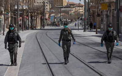 Israeli border police wear face masks as they patrol Jerusalem city center to check people are not disobeying the governments orders on a partial lockdown in order to prevent the spread of the Coronavirus, April 03, 2020.(Nati Shohat/Flash90)