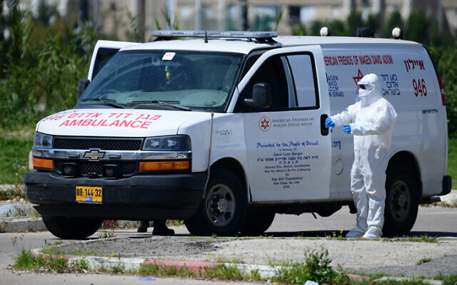 Israeli Magen David Adom personel and soldiers at a drop off station for residents from Bnei Brak who have been infected by the Coronavirus, and on their way to quarantine hotels, near the Ayalon mall on April 3, 2020. (Tomer Neuberg/ Flash90) Israeli Magen David Adom personel and soldiers at a drop off station for residents from Bnei Brak who have been infected by the Coronavirus, and on their way to quarantine hotels, near the Ayalon mall on April 3, 2020. (Tomer Neuberg/ Flash90)