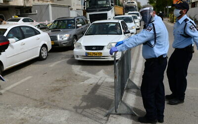 Police officers at a checkpoint located at the entrance to the ultra-Orthodox city of Bnei Brak, April 5, 2020. (Tomer Neuberg/Flash90)