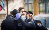 Police officers close synagogues and hand out fines to ultra-Orthodox Jews in the Bukharim quarter in Jerusalem on April 6, 2020. (Yonatan Sindel/Flash90)