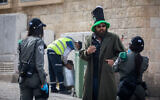 Border Police officers talk to a man in downtown Jerusalem on April 6, 2020. (Yonatan Sindel/Flash90)