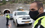 Police at a temporary 'checkpoint' on Highway 60 outside Jerusalem on April 10, 2020, to check if people are disobeying the government's orders on a partial lockdown, in order to prevent the spread of the coronavirus. (Nati Shohat/Flash90)