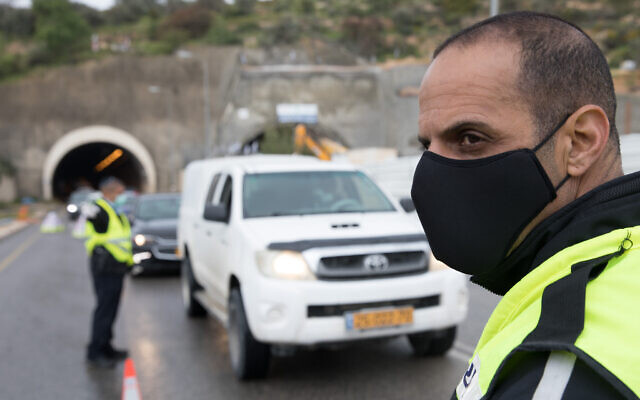 Police at a temporary 'checkpoint' on Highway 60 outside Jerusalem on April 10, 2020, to check if people are disobeying the government's orders on a partial lockdown, in order to prevent the spread of the coronavirus. (Nati Shohat/Flash90) Police at a temporary 'checkpoint' on Highway 60 outside Jerusalem on April 10, 2020, to check if people are disobeying the government's orders on a partial lockdown, in order to prevent the spread of the coronavirus. (Nati Shohat/Flash90)
