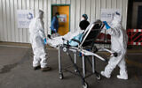 Magen David Adom paramedics take a patient with suspicion of coronavirus to the coronavirus unit at Shaare Zedek Medical Center in Jerusalem, April 10, 2020. (Nati Shohat/Flash90)