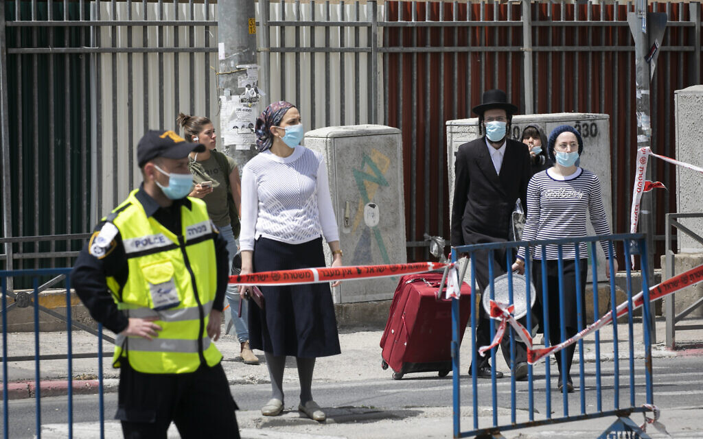 Ultra-Orthodox pedestrians cross an Israeli police roadblock in an ultra-Orthodox neighborhood of Jerusalem on April 19, 2020.(Olivier Fitoussi/Flash90) Ultra-Orthodox pedestrians cross an Israeli police roadblock in an ultra-Orthodox neighborhood of Jerusalem on April 19, 2020.(Olivier Fitoussi/Flash90)