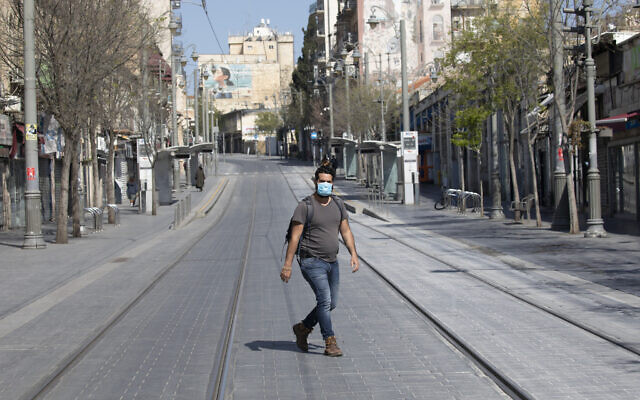 An Israeli man with a face mask walks in an empty street in Jerusalem on April 14, 2020 (Olivier Fitoussi/Flash90 An Israeli man with a face mask walks in an empty street in Jerusalem on April 14, 2020 (Olivier Fitoussi/Flash90