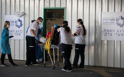 Medical personnel at Shaare Zedek Medical Center in Jerusalem receive a patient suspected of having the coronavirus on April 16, 2020. (Nati Shohat/Flash90)