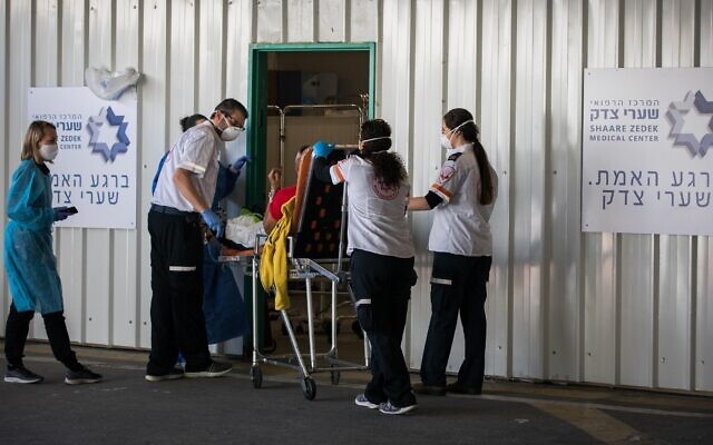 Medical personnel at Shaare Zedek Medical Center in Jerusalem receive a patient suspected of having the coronavirus on April 16, 2020. (Nati Shohat/Flash90) Medical personnel at Shaare Zedek Medical Center in Jerusalem receive a patient suspected of having the coronavirus on April 16, 2020. (Nati Shohat/Flash90)