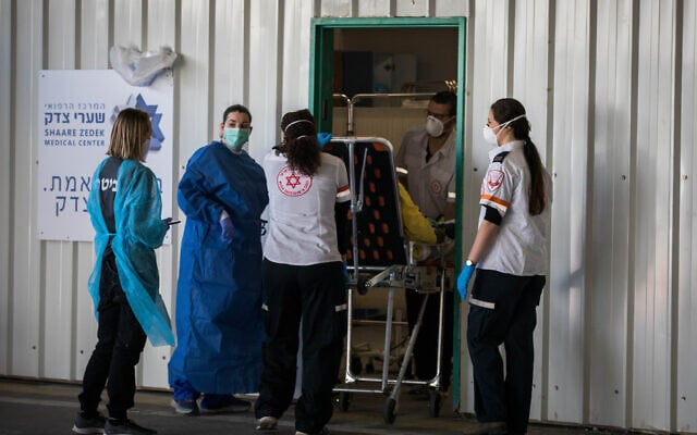 A medical team receives a patient with suspected coronavirus at Shaare Zedek hospital in Jerusalem, April 16, 2020 (Nati Shohat/Flash90) A medical team receives a patient with suspected coronavirus at Shaare Zedek hospital in Jerusalem, April 16, 2020 (Nati Shohat/Flash90)