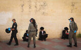 Police officers close synagogues and hand out fines in the city of Beit Shemesh to ultra-Orthodox Jews who violated coronavirus regulations, April 16, 2020. (Yaakov Lederman/Flash90)
