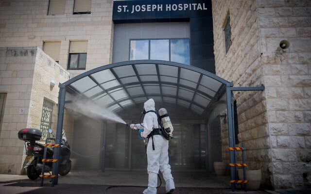 An Israeli firefighter disinfect the entrance to St Joseph hospital in East Jerusalem on April 16, 2020, as preventive measures against the spread of the coronavirus. (Yonatan Sindel/Flash90) An Israeli firefighter disinfect the entrance to St Joseph hospital in East Jerusalem on April 16, 2020, as preventive measures against the spread of the coronavirus. (Yonatan Sindel/Flash90)