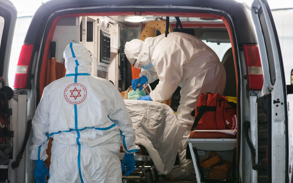 Magen David Adom medics wearing protective clothing evacuate a suspected coronavirus patient to the coronavirus unit at Shaare Zedek hospital in Jerusalem, April 20, 2020. (Nati Shohat/Flash90) Magen David Adom medics wearing protective clothing evacuate a suspected coronavirus patient to the coronavirus unit at Shaare Zedek hospital in Jerusalem, April 20, 2020. (Nati Shohat/Flash90)