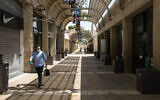 A man walks past closed stores in the Mamilla Mall in Jerusalem on April 22, 2020. (Olivier Fitoussi/Flash90)