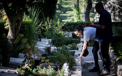 A woman visits the grave of a family member at the military cemetery on Mount Herzl in Jerusalem on April 22, 2020. (Photo by Yonatan Sindel/Flash90)