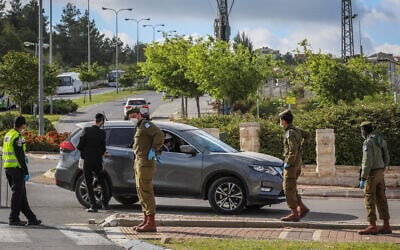 Israeli police and soldiers guard at a roadblock at the entrance to a neighborhood in the city of Beit Shemesh on April 26, 2020. (Yaakov Lederman/Flash90)