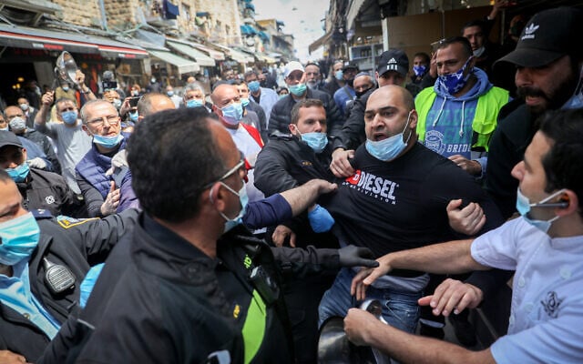 Store owners at Jerusalem's Mahane Yehuda market scuffle with police during a protest over the continued closure of open-air markets, April 25, 2020. (Yonatan Sindel/Flash90) Store owners at Jerusalem's Mahane Yehuda market scuffle with police during a protest over the continued closure of open-air markets, April 25, 2020. (Yonatan Sindel/Flash90)