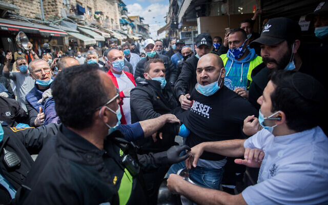 Police arrest a man during a protest by stall-owners at the Mahane Yehuda market in Jerusalem against the ongoing closure of their businesses, April 26, 2020. (Yonatan Sindel/Flash90) Police arrest a man during a protest by stall-owners at the Mahane Yehuda market in Jerusalem against the ongoing closure of their businesses, April 26, 2020. (Yonatan Sindel/Flash90)