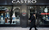An ultra-Orthodox Jewish man walks past a closed shop of the 'Castro' fashion chain in downtown Jerusalem on April 26, 2020. (Yonatan Sindel/Flash90)