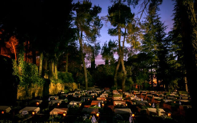 Candles are seen at the graves of fallen soldiers, at the Mount Herzl Military Cemetery on April 27, 2020. Cemeteries were shut Monday to prevent the spread of coronavirus (Olivier Fitoussi/Flash90) Candles are seen at the graves of fallen soldiers, at the Mount Herzl Military Cemetery on April 27, 2020. Cemeteries were shut Monday to prevent the spread of coronavirus (Olivier Fitoussi/Flash90)