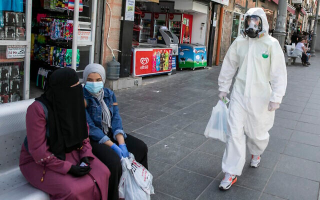 A man wearing a biological face mask and a protective suit does his shopping in downtown Jerusalem after the government eased some lockdown measures that it had imposed in order to stop the spread of the coronavirus, on April 27, 2020.
(Olivier Fitoussi/Flash90) A man wearing a biological face mask and a protective suit does his shopping in downtown Jerusalem after the government eased some lockdown measures that it had imposed in order to stop the spread of the coronavirus, on April 27, 2020.
(Olivier Fitoussi/Flash90)