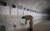 Israeli soldier places flowers and salute on graves of fallen Israeli soldiers, at Mount Herzl Military Cemetery on April 27, 2020.(Yonatan Sindel/Flash90)