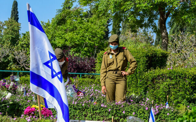 Israeli soldiers near the graves of fallen soldiers at the Kiryat Shaul Military Cemetery as Israel marks Memorial Day for the fallen soldiers and victims of terror on April 28, 2020. (Avshalom Sassoni/Flash90) Israeli soldiers near the graves of fallen soldiers at the Kiryat Shaul Military Cemetery as Israel marks Memorial Day for the fallen soldiers and victims of terror on April 28, 2020. (Avshalom Sassoni/Flash90)