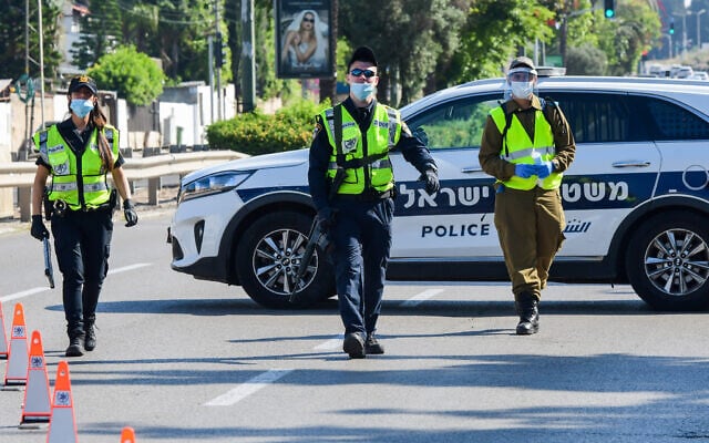 Israeli police and soldiers guard at a roadblock on a road leading to the Kiryat Shaul Military Cemetery, as Israel marks Memorial Day on April 28, 2020. (Avshalom Sassoni/Flash90) Israeli police and soldiers guard at a roadblock on a road leading to the Kiryat Shaul Military Cemetery, as Israel marks Memorial Day on April 28, 2020. (Avshalom Sassoni/Flash90)
