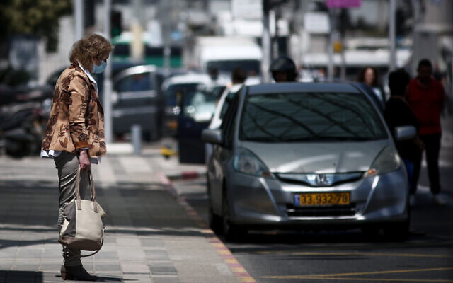 People stand still as a two-minute siren sounds across Israel, marking Memorial Day which commemorates fallen Israeli soldiers and victims of terror, Tel Aviv, April 28, 2020 (Miriam Alster/Flash90)