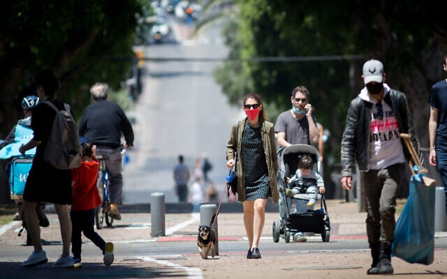 People wear protective masks to protect them from the coronavirus in Tel Aviv on April 28, 2020. (Miriam Alster/Flash90) People wear protective masks to protect them from the coronavirus in Tel Aviv on April 28, 2020. (Miriam Alster/Flash90)