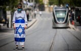 People stand for a two-minute silence in Jerusalem on Memorial Day, Yom Hazikaron, April 28, 2020. (Yonatan Sindel/Flash90)