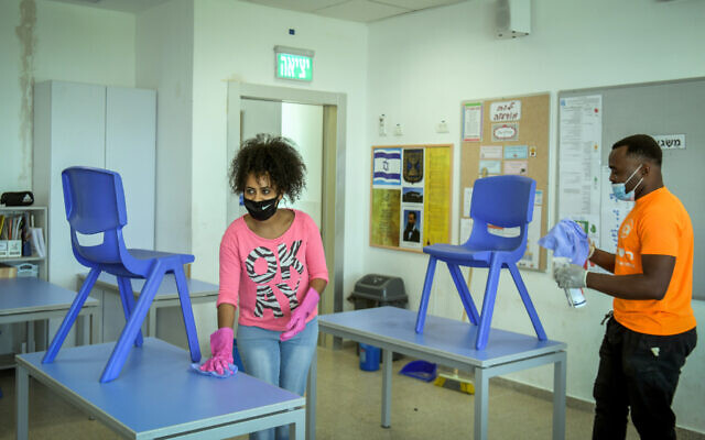 Workers clean a classroom at Luba Eliav primary school in Rishon Lezion on April 30, 2020. (Flash90)