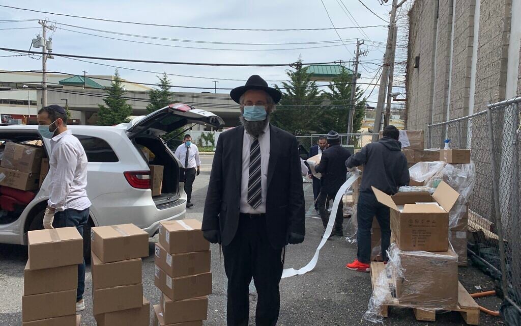 Rabbi Eitan Rubin with a delivery of personal protective equipment in the parking lot of Beit Midrash of Great Neck, New York. (Cathryn J. Prince/ Times of Israel)