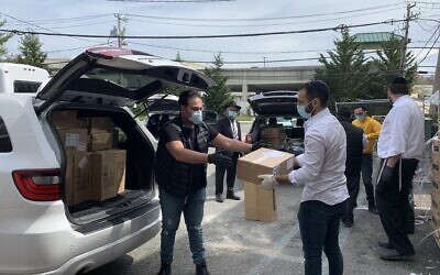 Volunteers including students and professionals load up personal protective equipment in the parking lot of Beit Midrash of Great Neck. (Cathryn J. Prince/ Times of Israel)