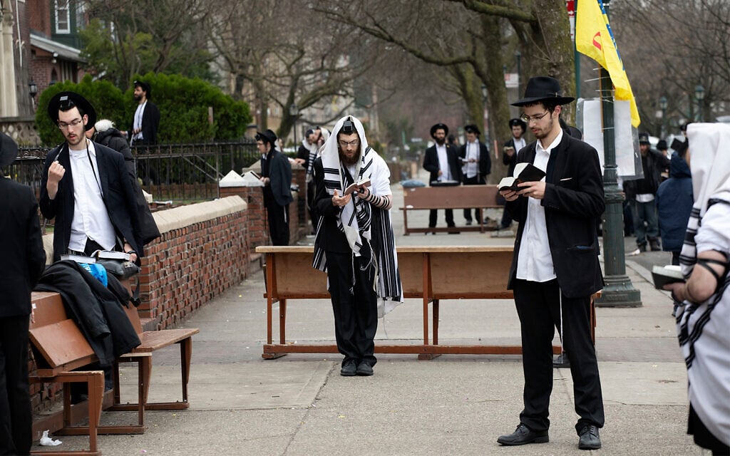 Ultra-Orthodox Jewish men use social distancing as they pray outside the Chabad Lubavitch World Headquarters, in Brooklyn, New York, March 20, 2020. (AP/Mark Lennihan) Ultra-Orthodox Jewish men use social distancing as they pray outside the Chabad Lubavitch World Headquarters, in Brooklyn, New York, March 20, 2020. (AP/Mark Lennihan)