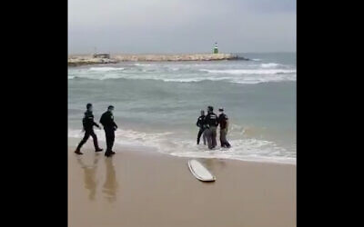 Police detain a surfer who allegedly refused to leave the water despite coronavirus regulations, April 24, 2020. (Screenshot/Twitter)