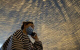 A woman walks past light decorations on a retail street in Wuhan, China, April 10, 2020. (AP/Ng Han Guan)