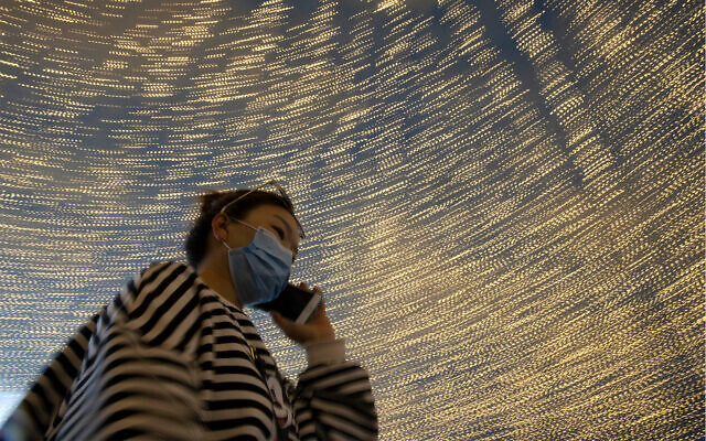 A woman walks past light decorations on a retail street in Wuhan, China, April 10, 2020. (AP/Ng Han Guan) A woman walks past light decorations on a retail street in Wuhan, China, April 10, 2020. (AP/Ng Han Guan)