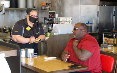 A customer orders food at a Waffle House restaurant in Savannah, Georgia, April 27, 2020. (AP/Russ Bynum) A customer orders food at a Waffle House restaurant in Savannah, Georgia, April 27, 2020. (AP/Russ Bynum)