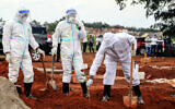 Public health officers at the grave of a coronavirus fatality at the Langata cemetery in Nairobi, Kenya, April 16, 2020. (AP/Patrick Ngugi)