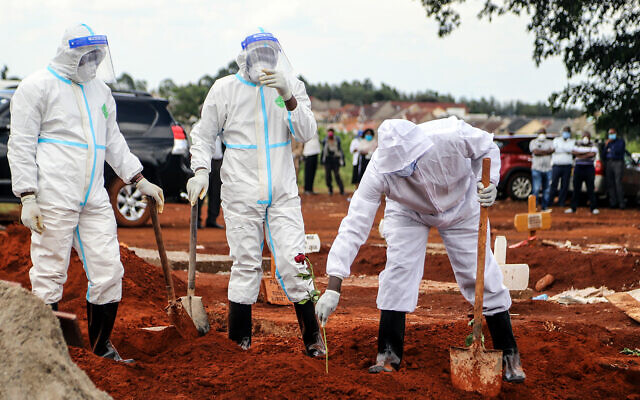 Public health officers at the grave of a coronavirus fatality at the Langata cemetery in Nairobi, Kenya, April 16, 2020. (AP/Patrick Ngugi) Public health officers at the grave of a coronavirus fatality at the Langata cemetery in Nairobi, Kenya, April 16, 2020. (AP/Patrick Ngugi)