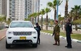 An IDF officer helps police run a checkpoint during the coronavirus outbreak on April 2, 2020. (Israel Defense Forces)