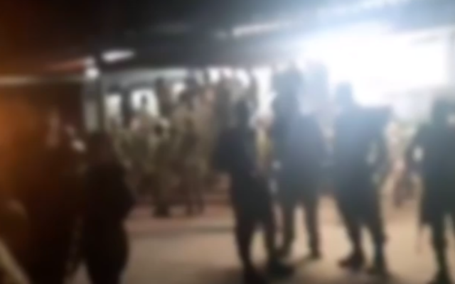 Blurry footage aired on Channel 12 on April 3, 2020, shows a large gathering of soldiers outside a mess hall at a base in central Israel (video screenshot) Blurry footage aired on Channel 12 on April 3, 2020, shows a large gathering of soldiers outside a mess hall at a base in central Israel (video screenshot)