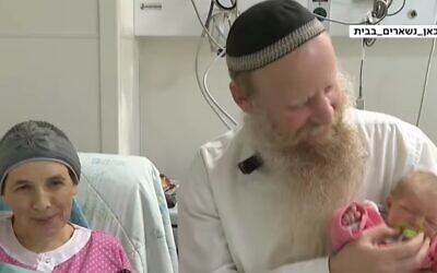 Shira (L) and Eitan (R) Shnerb, whose daughter Rina was killed in a terror attack, with their new baby daughter, April 22, 2020 (Screen grab/Kan)