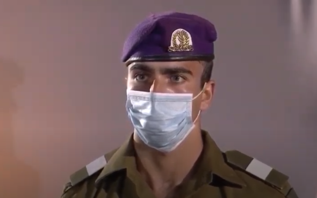 A soldier wearing a protective mask stand at attention at the national opening ceremony for Israel's Memorial Day for fallen soldeirs and victims of terror, at the Western Wall in Jerusalem, April 27, 2020 (video screenshot) A soldier wearing a protective mask stand at attention at the national opening ceremony for Israel's Memorial Day for fallen soldeirs and victims of terror, at the Western Wall in Jerusalem, April 27, 2020 (video screenshot)